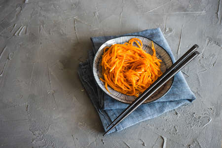 Organic spicy carrot salad on rustic table with copyspace as an organic food conceptの写真素材
