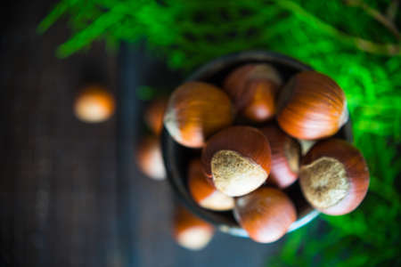 Christmas spices lika an anise star, cinnamon sticks and nuts on dark wooden tableの写真素材