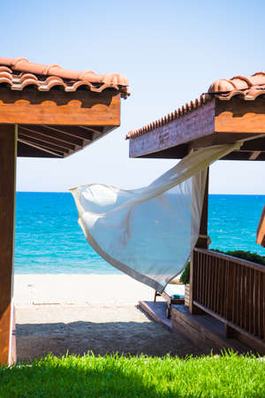 summertime relax on the sand beach with sea waves and beach cabinの写真素材