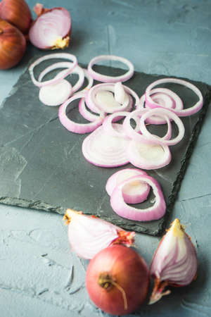 Organic food concept with red onion on dark cutting board with copyspaceの写真素材