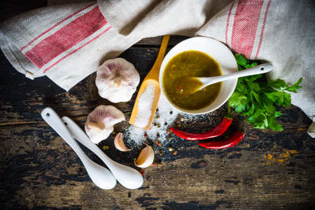 Traditional georgian sauce green tkemali with raw products on rustic wooden tableの写真素材