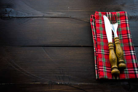 Rustic table setting with bright napkin nd silverware on dark wooden tableの写真素材