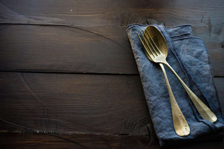 Rustic table setting with bright napkin nd silverware on dark wooden tableの写真素材