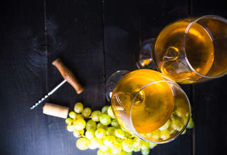 Organic ripe grape and vintage corkscrew on rustic background as a wine concept