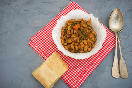 Traditional georgian dish - lobio in bright ceramic bowl on dark rustic wooden table with copyspace