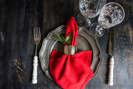 Rustic table setting with vintage tableware  and branch of Christmas tree  on dark wooden table with copyspaceの写真素材