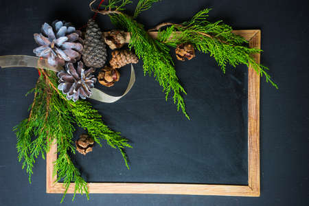 Christmas concet with chalkboard and pine cones  on dark wooden tableの写真素材