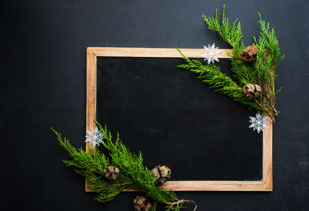Christmas concet with chalkboard and pine cones  on dark wooden tableの写真素材