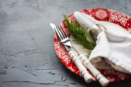 Rustic festive table setting with vintage tableware and Christmas decoration on grey concrete  table...