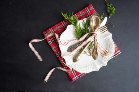 Rustic festive table setting with vintage tableware and Christmas decoration on grey concrete  table...
