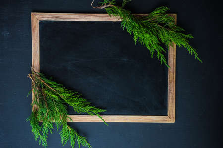 Christmas concet with chalkboard and pine cones  on dark wooden tableの写真素材