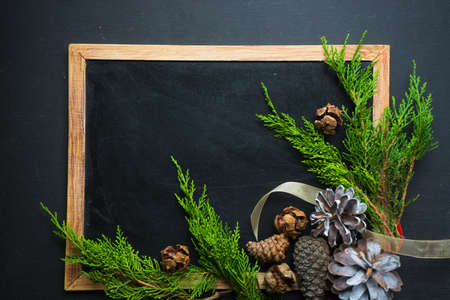 Christmas concet with chalkboard and pine cones  on dark wooden tableの写真素材