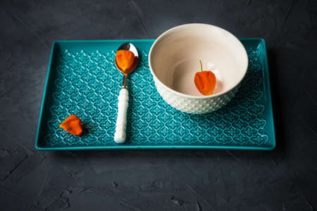 Autumnal table setting with bright yellow leaves and physalis  on old wooden table with copyspaceの写真素材