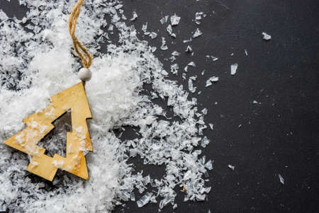 Festive Christmas concept with snow and decoration on rustic flatlay and frame with copyspaceの写真素材