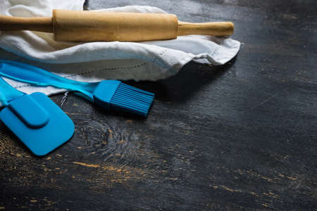 Cooking concept with cookies forms, napkin and notepad  on dark wooden table with copyspace