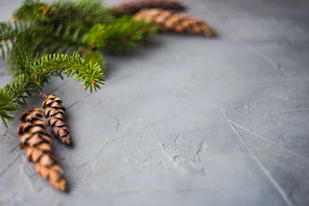 Christmas concept with gift boxes, ribbon and cones on rustic concrete background with copyspace