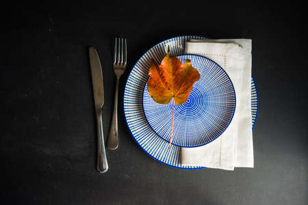 Autumnal table setting with bright red and orange wild berries on rustic background with copyspaceの写真素材