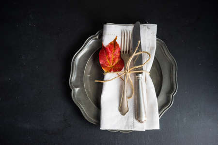 Autumnal table setting with bright red and orange wild berries on rustic background with copyspace