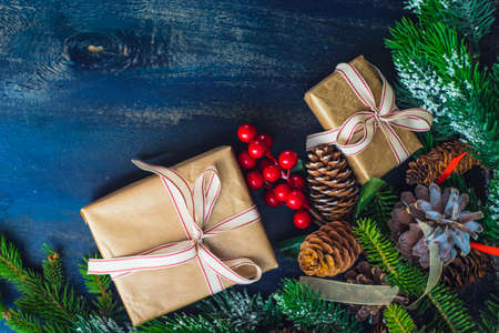 Christmas concept with gift boxes, ribbon and cones on rustic concrete background with copyspaceの写真素材