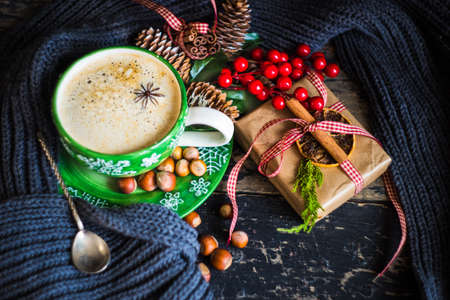 Cup of coffee with spices and christmas decorations on old wooden background with copy spaceの写真素材