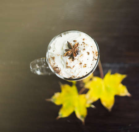 Autumnal concept with bright yellow leaves and cup of coffee  in rustic style with copyspaceの写真素材