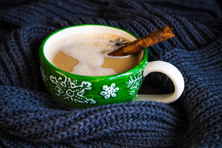Cup of coffee with spices and christmas decorations on old wooden background with copy spaceの写真素材