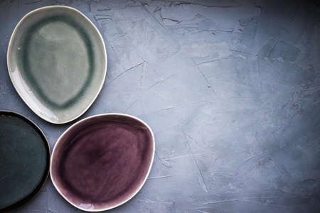 Rustic table setting with bright blue plate on grey concrete tableの写真素材
