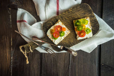 Healthy dinner concept with healthy bread and organic cherry tomatoes on rustic backgroundの写真素材