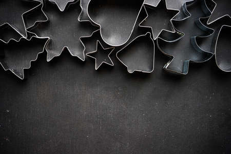 Christmas holiday concept with cookies cutters on blackboardの写真素材