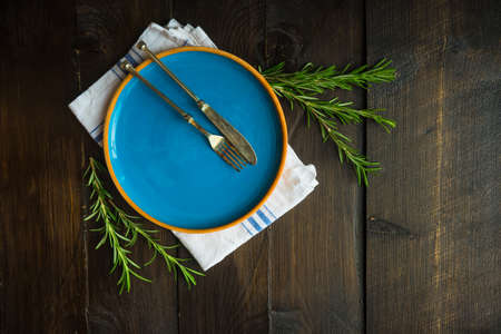 Rustic table setting with vintage tableware  and rosemary herb  on  a table with copyspaceの写真素材