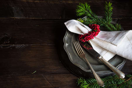 Festive table setting for Christmas dinner on dark wooden table