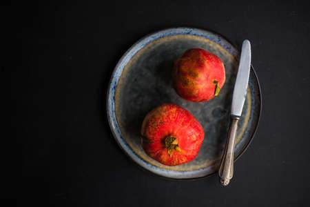 Ripe organic pomegranate fruit on rustic wooden table with copyspaceの写真素材