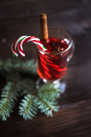 Mulled wine in a glass and christmas time decorations on rustic wooden tableの写真素材