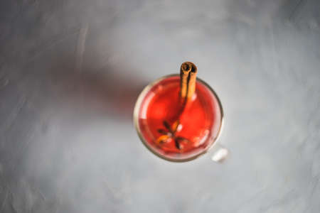 Mulled wine in a glass and christmas time decorations on rustic wooden tableの写真素材