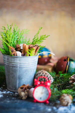 Christmas frame with fir tree branch, red berries and decorations on rustic backgroundの写真素材