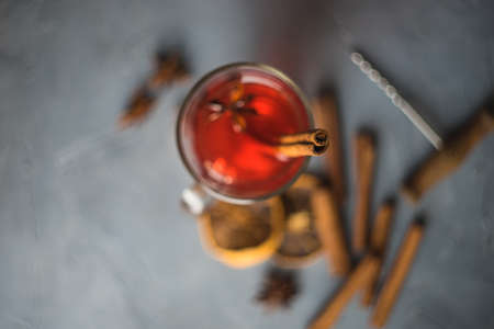Mulled wine in a glass and christmas time decorations on rustic wooden tableの写真素材