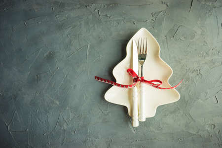 Rustic table setting for festive Christmas dinner with vintage decor on concrete grey background