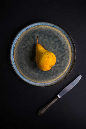 Fresh organic pears on vintage plate on old wooden kitchen tableの写真素材
