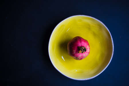 Ripe organic pomegranate fruit on rustic wooden table with copyspaceの写真素材