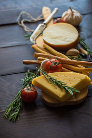 Different typs of georgian cheese on rustic wooden board with organic vegetables and herbsの写真素材