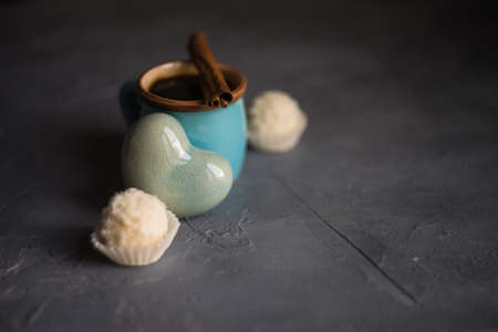 Mug of coffee with candies on grey concrete backgroundの写真素材