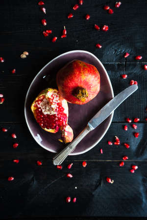 Ripe organic pomegranate fruit on rustic wooden table with copyspaceの写真素材