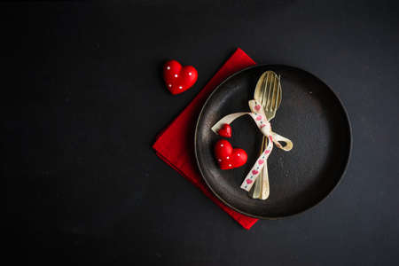 Rustic table setting for festive  dinner in Valentines Day with vintage heart-shaped decor on concrete grey backgroundの写真素材