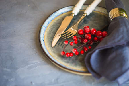 Festive table setting for Christmas dinner on grey concrete table