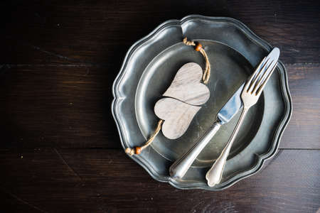 Table setting for festive dinner in St. Valentines Day or wedding on dark wooden table with copyspaceの写真素材