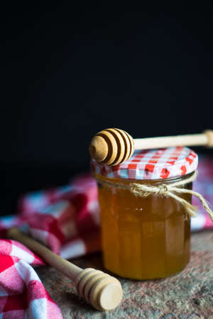 Organic honey in a jar and honey spoons on rustic background with copyspaceの写真素材