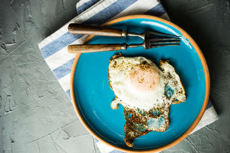 Traditional european breakfast with fried eggs on rustic plateの写真素材