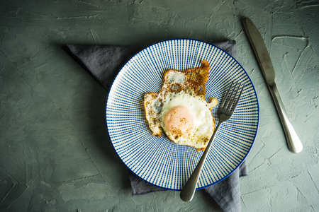 Traditional european breakfast with fried eggs on rustic plateの写真素材