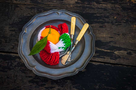 Ripe organic tangerines on rustic plate with knife for citrus on wooden table with copyspaceの写真素材