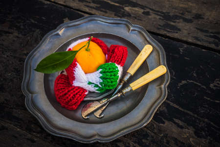 Ripe organic tangerines on rustic plate with knife for citrus on wooden table with copyspaceの写真素材